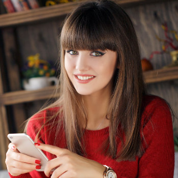 Girl reading SMS on mobile phone Duluth Dental Studio care