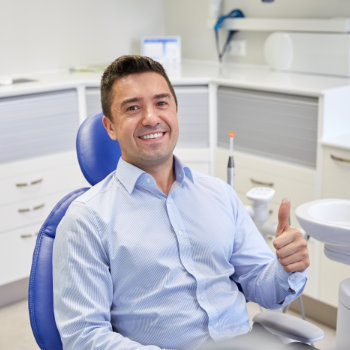 Satisfied man thumbs up in dentist chair Duluth Dental Studio